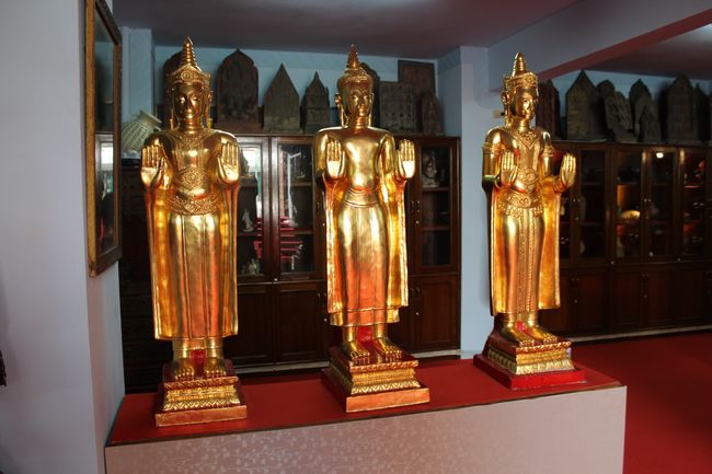 Wat Intharawihan: Drei goldene, stehende Buddha mit je zwei Händen nach vorne ausgestreckt