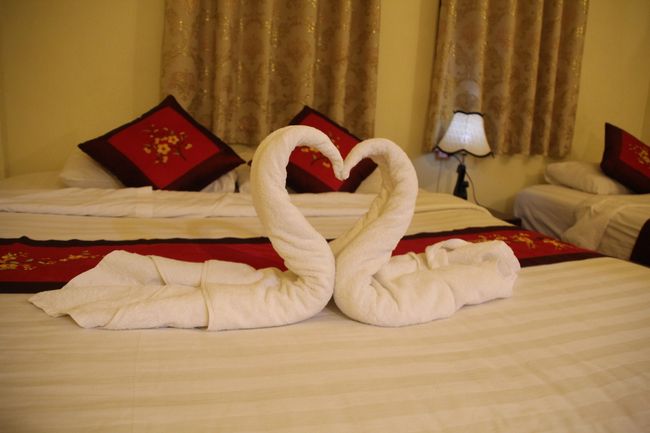 The towels on the bed folded into swans to form a heart