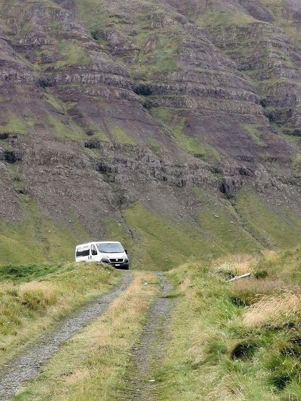 Small car in front of a huge mountain