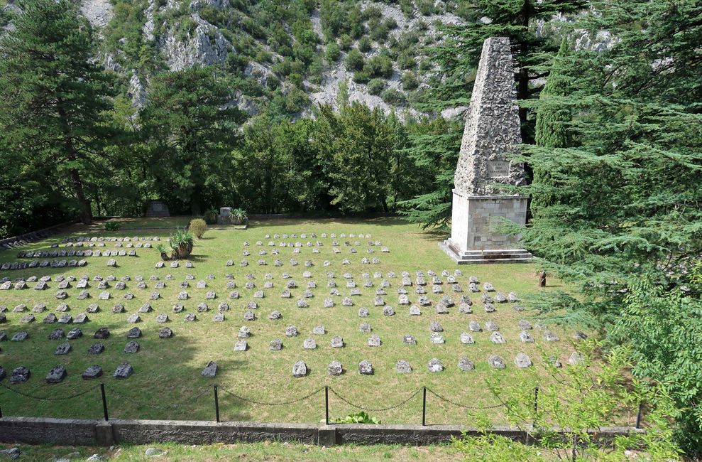 Ein vom fahrenden Zug aus fotographierter Soldatenfriedhof mit deutschsprachigen Inschriften, der an die Isonzo-Schlachten des 1.Weltkriegs erinnert. 