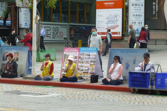 Vor dem Mengjia Longshan-Tempel saßen Leute auf dem Fußweg und haben gebetet/meditiert.