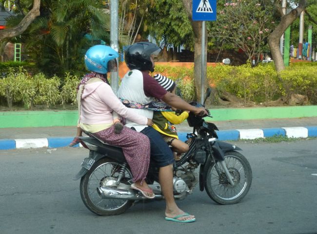 Family trip on the moped - note the child's 'seat belt' in the yellow t-shirt