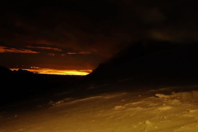 Bei Nacht leuchtet La Paz von Weitem waehrend wir uns durch den Schnee wuehlen.