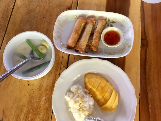 Nachtisch, unten: Kokosreis mit Mango, links: Kokosmilch mit Bananen, oben: Thailändische Frühlingsrollen
