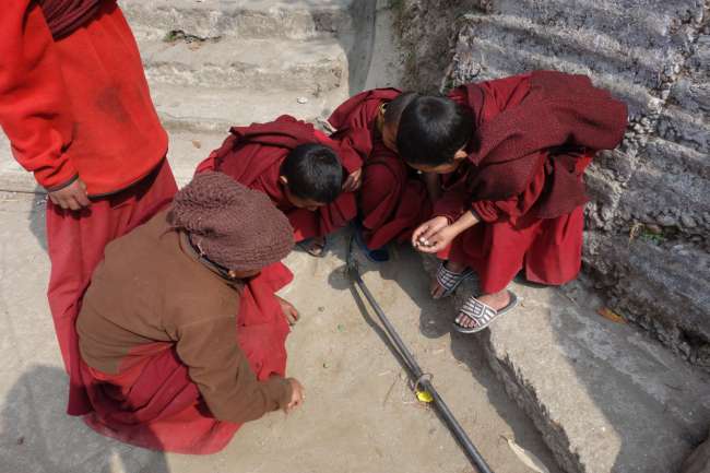 Little monks playing marbles