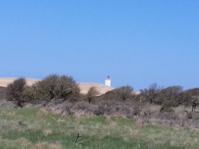 the lighthouse is swallowed by a sand dune