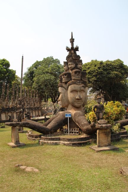 Mehrköpfige Statue mit mehreren kleinen (Toten-) Köpfen auf dem Kopf und krakenartig vielen Armen