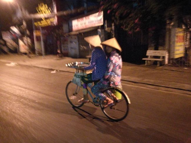 Zwei Vietnamesen auf einem Fahrrad.