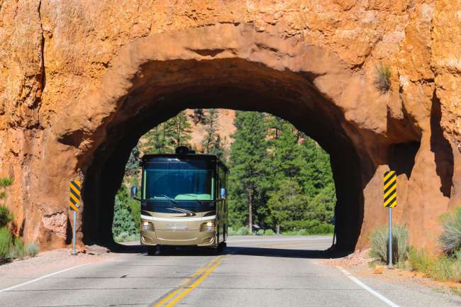 Drive through a natural tunnel in the Red Canyon