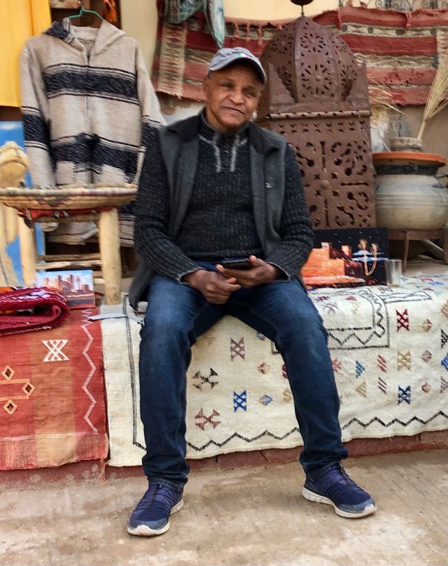 Hassan in front of his shop.
