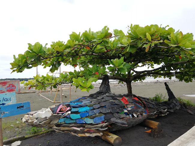 Statue made of washed up trash and flip flops