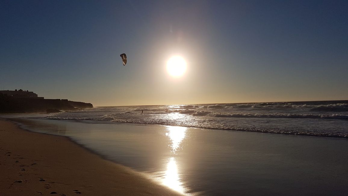 Kitesurfers soaring over the surf
