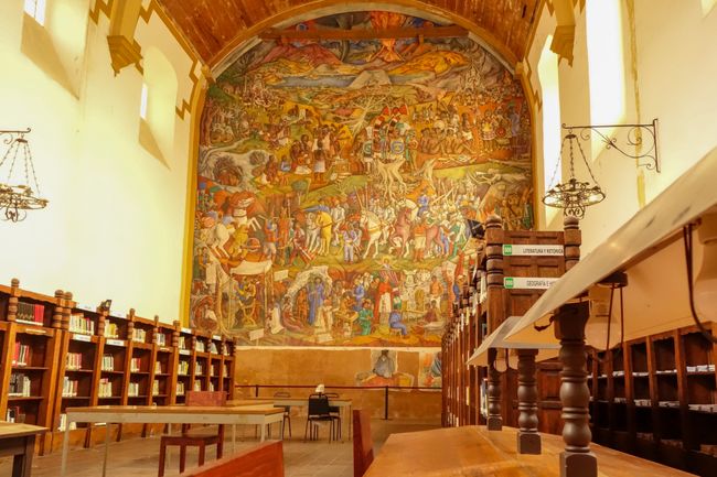 Die Bibliothek mit einem riesigen Wandgemälde. 