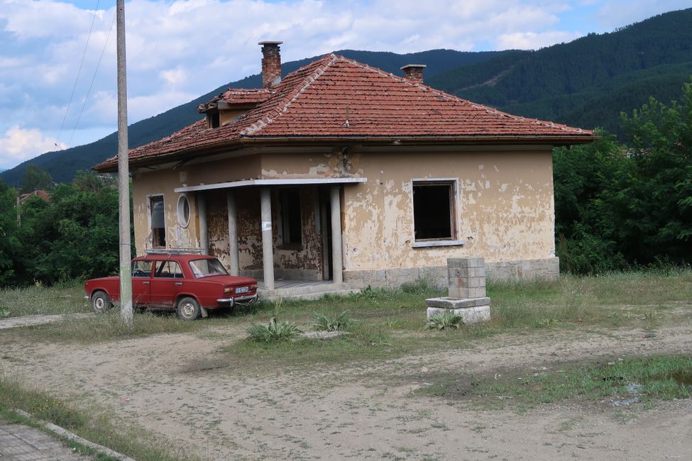 Immer noch sehr häufig anzutreffendes bulgarisches Stilleben: Ein ehemaliger Ostblockkübel vor verfallen wirkender Bausubstanz.