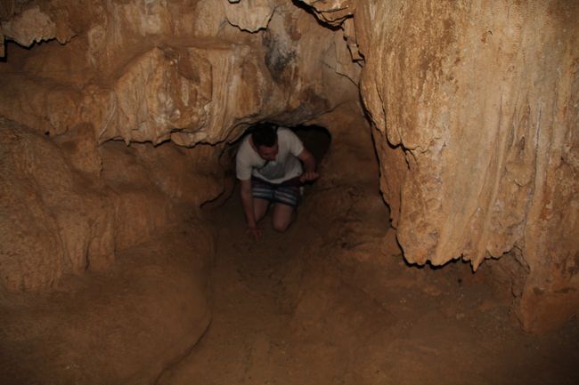 Jonas krabbelt durch einen kleinen Durchgang in der Höhle