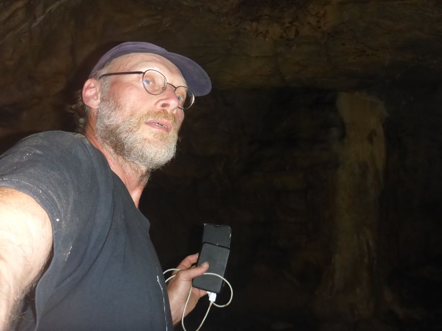 Mit Taschenlampenlicht vom Handy in der Grotte 