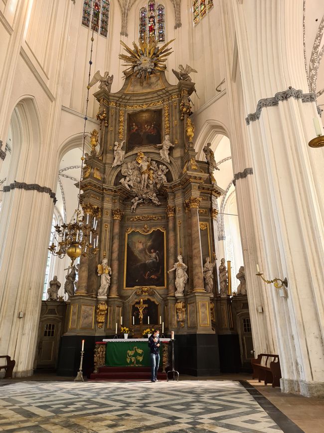 Der Altar der Kirche erstrecjt sich von der Decke bis zum Boden. Über den Menschen im Vordergrund lässt sich die größe des Altars gut nachvollziehen