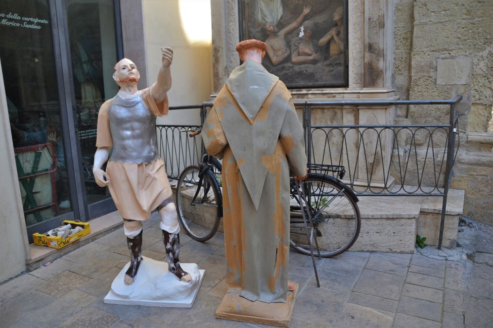 Zwei Figuren aus Pappmaché stehen zum Trocken vor dem Laden, in dem sie gefertigt wurden.