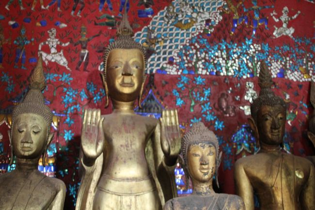Wat Xieng Thong: goldener Buddha vor einer mit Mosaik besetzen Wand
