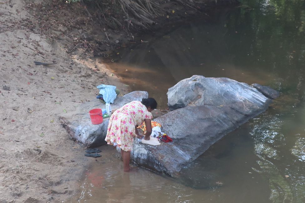 Eine Frau wäscht Wäsche am Fluss