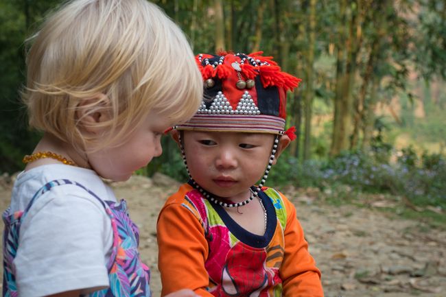 Die Kinder der Roten Dzao tragen während der ersten Jahre diese traditionelle Kopfbedeckung. Bestückt mit Glöckchen und Amuletten soll sie bösen Geistern das Fürchten lehren.