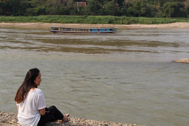 Franzi sitting on the 'beach' on the banks of the Mekong