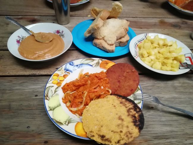Deftiges Frühstück mit Kürbismus, Torta, Arepa, Brot, Guavenmus und Ananas